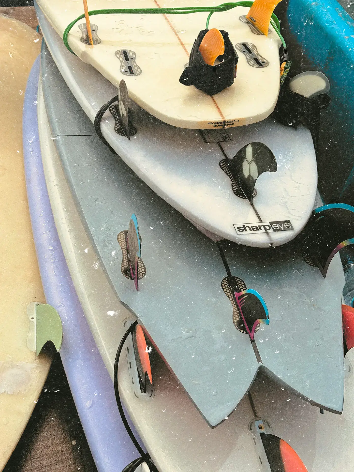 Surfboards stacked fins up, with the paper and scratch texture