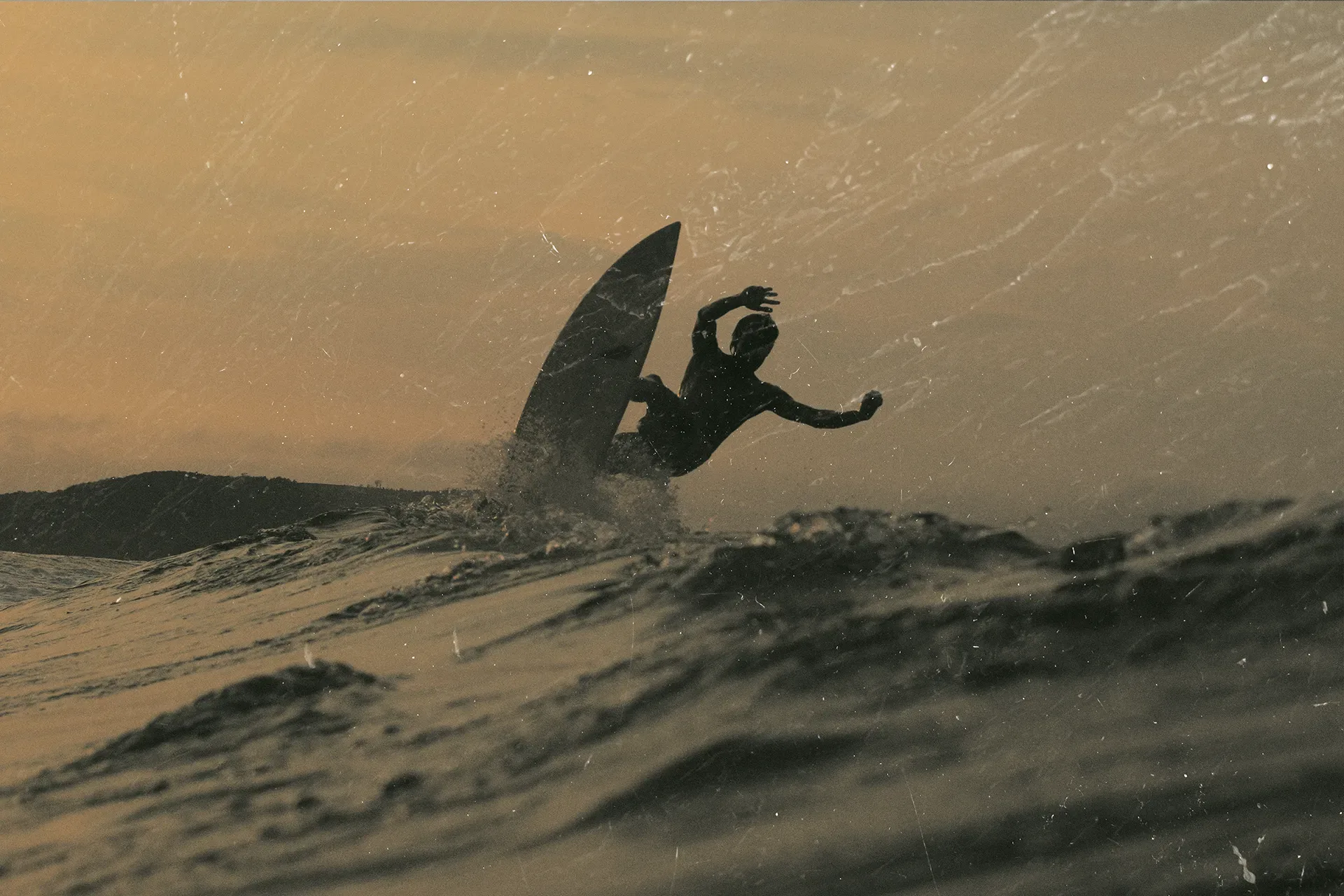 Calon surfing at sunset, in warm colours