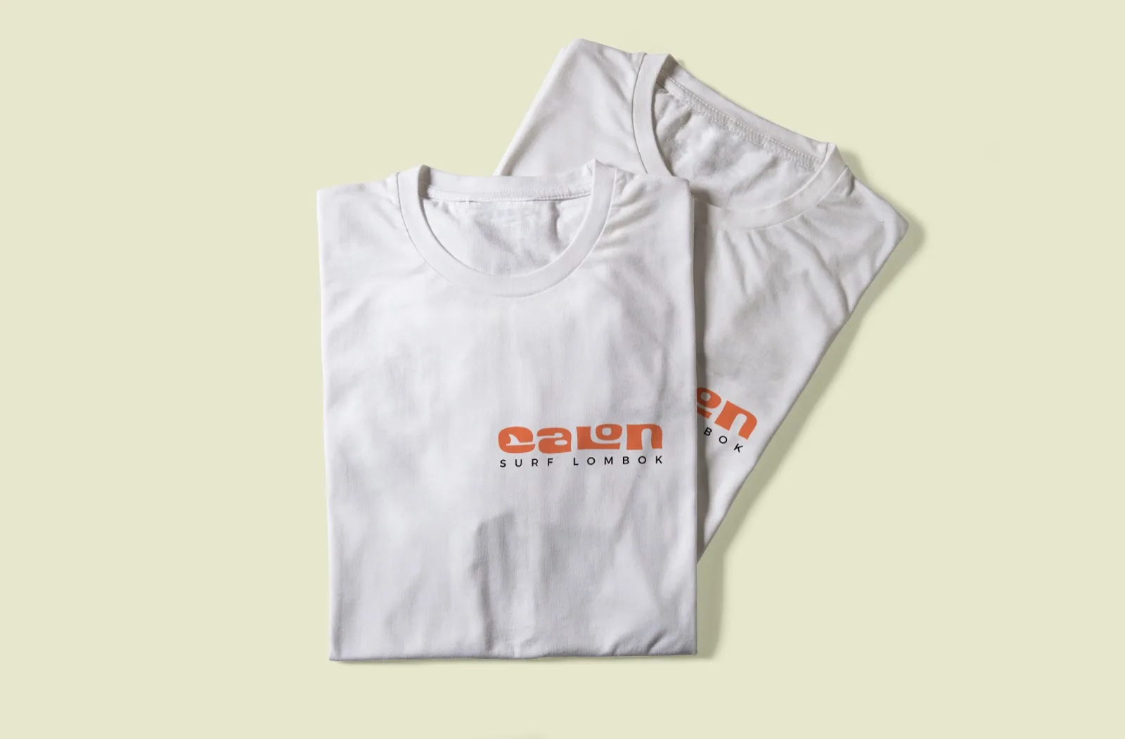 Two white Calon Surf T-shirts with the logo on the front